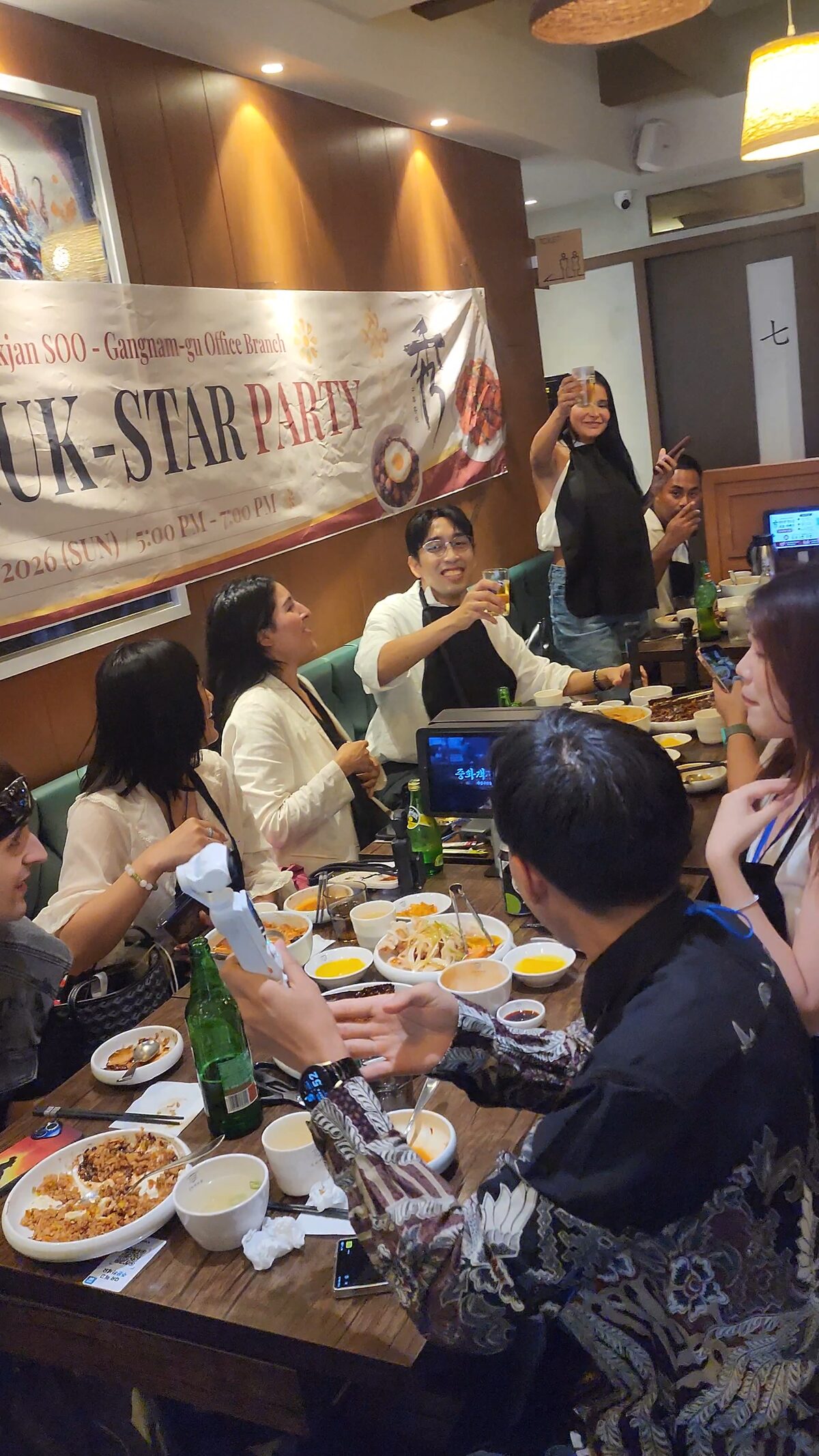 Mukstar Party guests raising their glasses together during the shared dinner