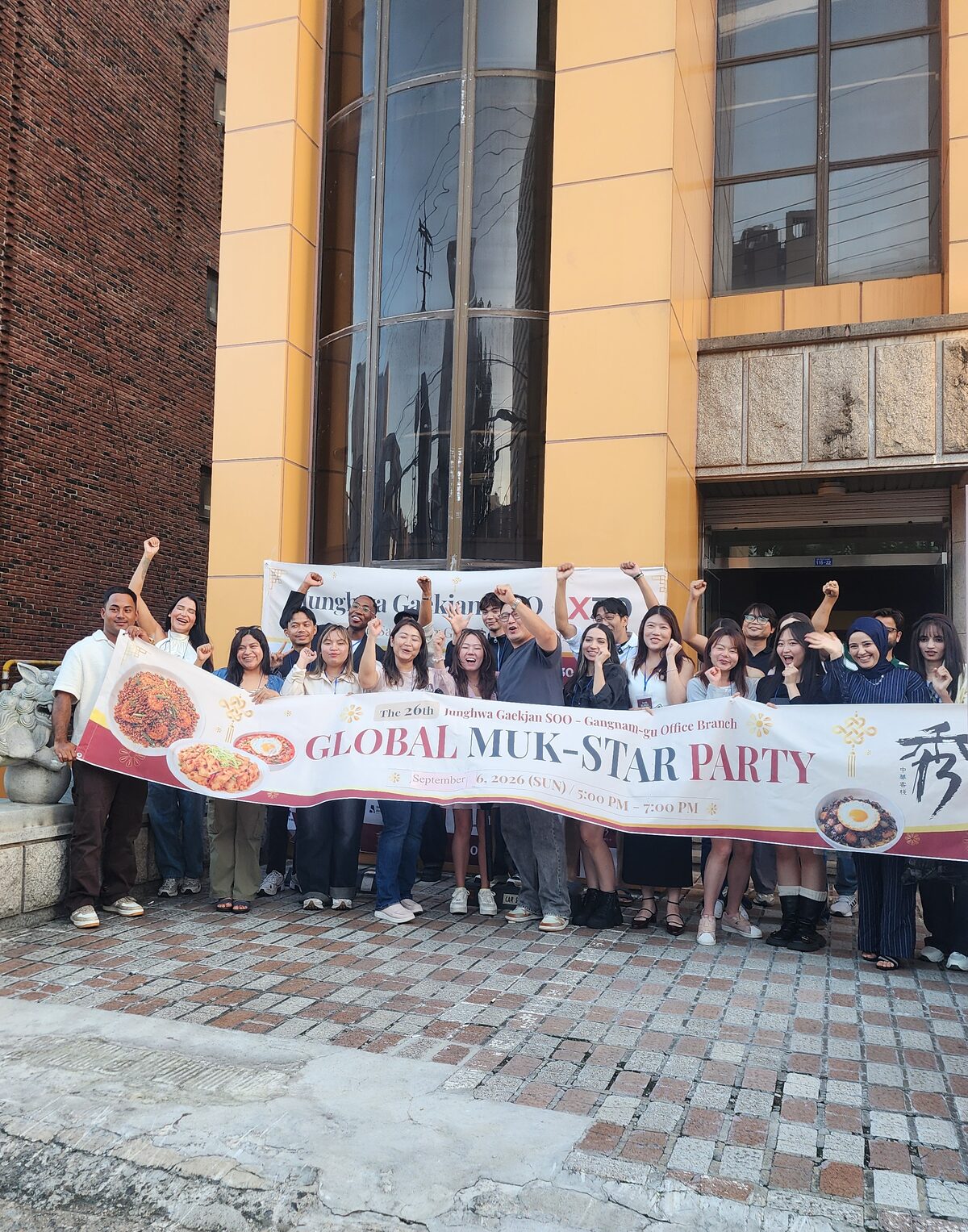 About 25 international creators holding the Global Muk-Star Party banner outside Junghwagaekjansu